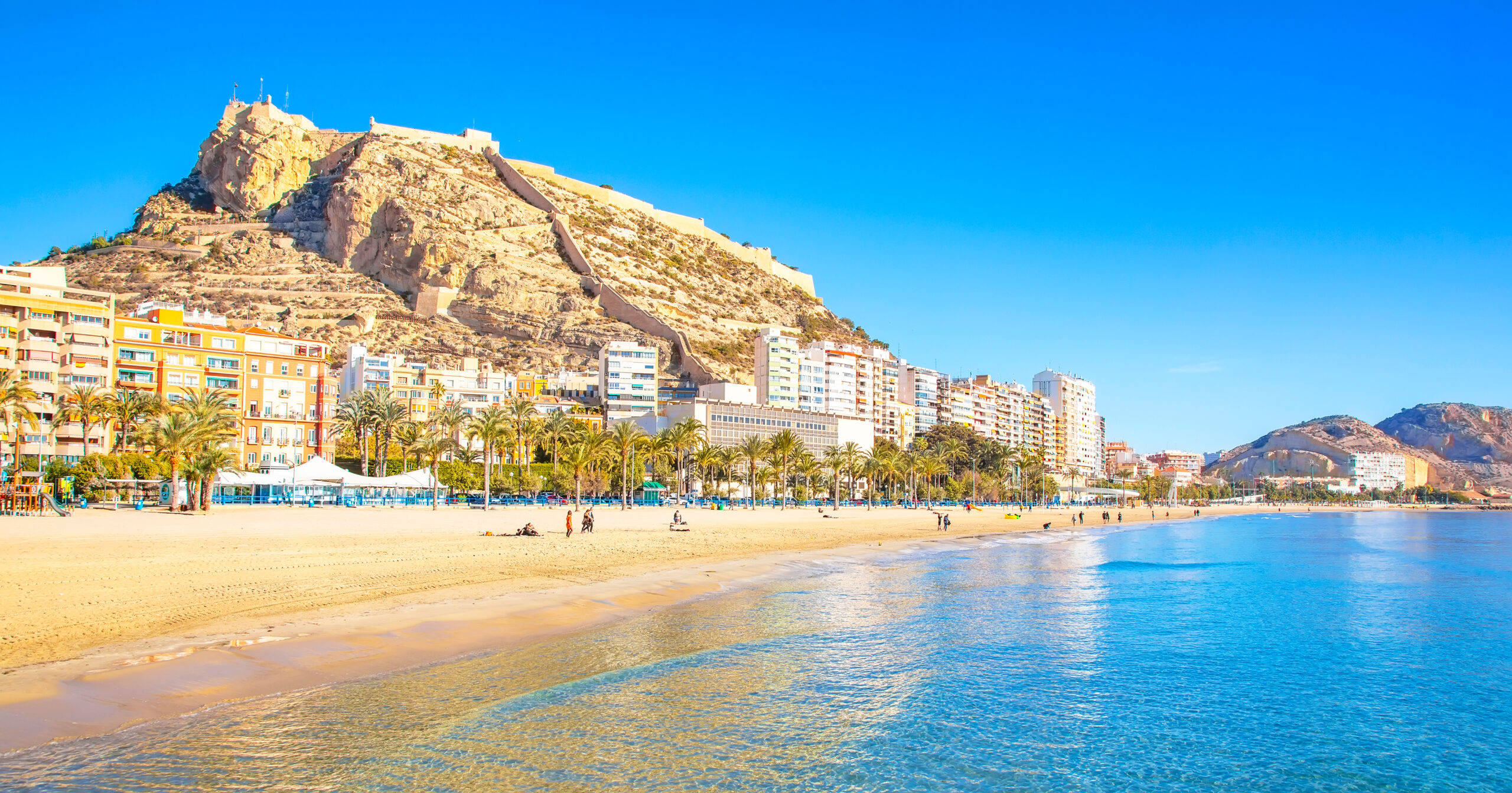 Vista panorámica del castillo de Santa Bárbara en Alicante desde el espigón de la playa de El Postiguet