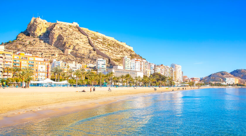 Vista panorámica del castillo de Santa Bárbara en Alicante desde el espigón de la playa de El Postiguet